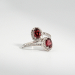 Bague bypass pour femme en argent 925 sertie de deux grenats rouges naturels entourés de zircons.