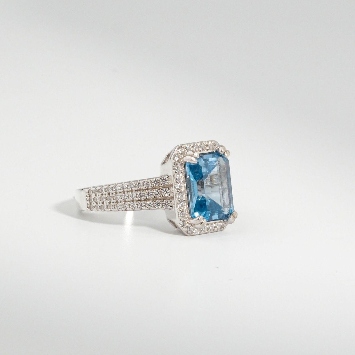 Bague pour femme en argent 925 sertie d'une topaze bleu néon naturelle taillée en baguette entourée de zircons.