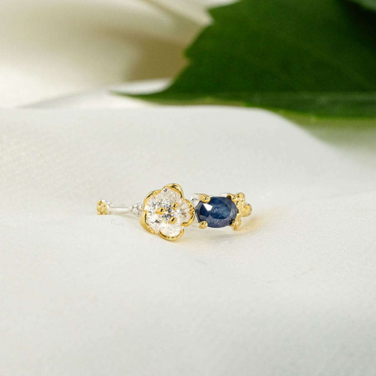 Orijinal yatay oval mavi safir taşlı gold detaylı gümüş çiçek figürlü ve dal dokulu 925 ayar gümüş kadın yüzük.