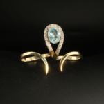 Bague deux doigts pour femme en argent 925 doré sertie d'une aigue-marine naturelle et de 0,17 ct de diamants.