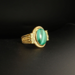 A gold-plated 925 sterling silver unisex ring featuring a natural oval cabochon malachite gemstone accented with round faceted peridot stones.