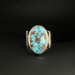 A 925 sterling silver handmade men's ring featuring a natural oval cabochon cut Nishapur turquoise gemstone with brown spiderweb matrix.