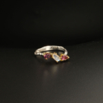 A 925 sterling silver women's ring featuring a natural oval moonstone flanked by two faceted pink rubellite tourmaline gemstones.