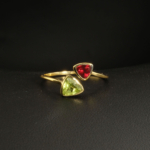 A gold-plated 925 sterling silver women's bypass ring featuring natural trillion-cut green peridot and red garnet gemstones.