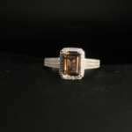 A 925 sterling silver women's ring featuring a natural baguette cut smoky quartz gemstone surrounded by cubic zirconia halo.