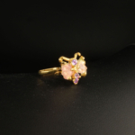 A 925 sterling silver gold-plated women's ring featuring carved pink tourmaline butterfly wings accented with purple amethyst gemstones.