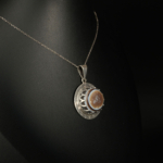Pendentif unisex en argent 925 serti d'une agate œillée naturelle taillée en cabochon avec bordure motif grec.