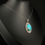 Pendentif unisex en argent 925 serti d'une turquoise naturelle taillée en cabochon avec bordure motif grec.