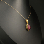 Pendentif pour femme en argent 925 doré sertie d'une tourmaline rose naturelle taillée en cabochon ovale.