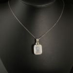 Pendentif pour femme en argent 925 serti d'une pierre de lune naturelle rectangulaire avec reflets bleus.